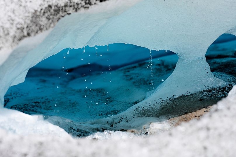 Water drips from a melting chunk of ice that originated from the Rhone glacier near Goms, Switzerland.