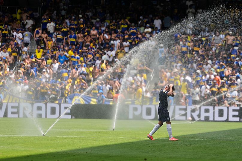 Auckland City's Gerard Garriga cools off under the sprinklers during a water break in the Club World Cup.