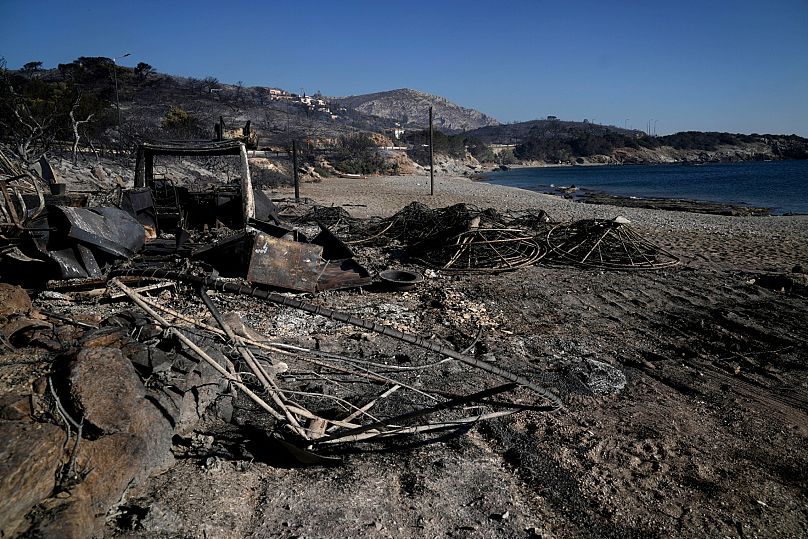 Burned sunshades are seen at a beach in Thymari, south of Athens, Thursday, 26 June, 2025