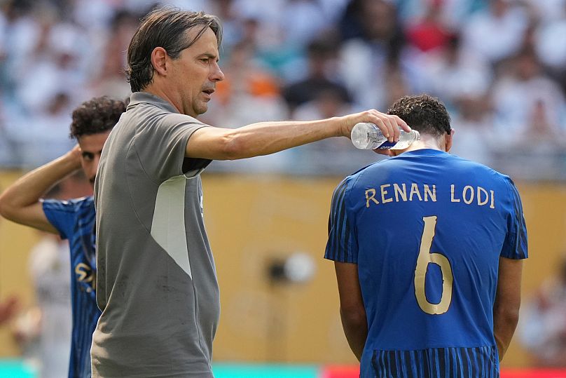 Al-Hilal manager Simone Inzaghi, left, uses water to cool down his player Renan Lodi during the Club World Cup.