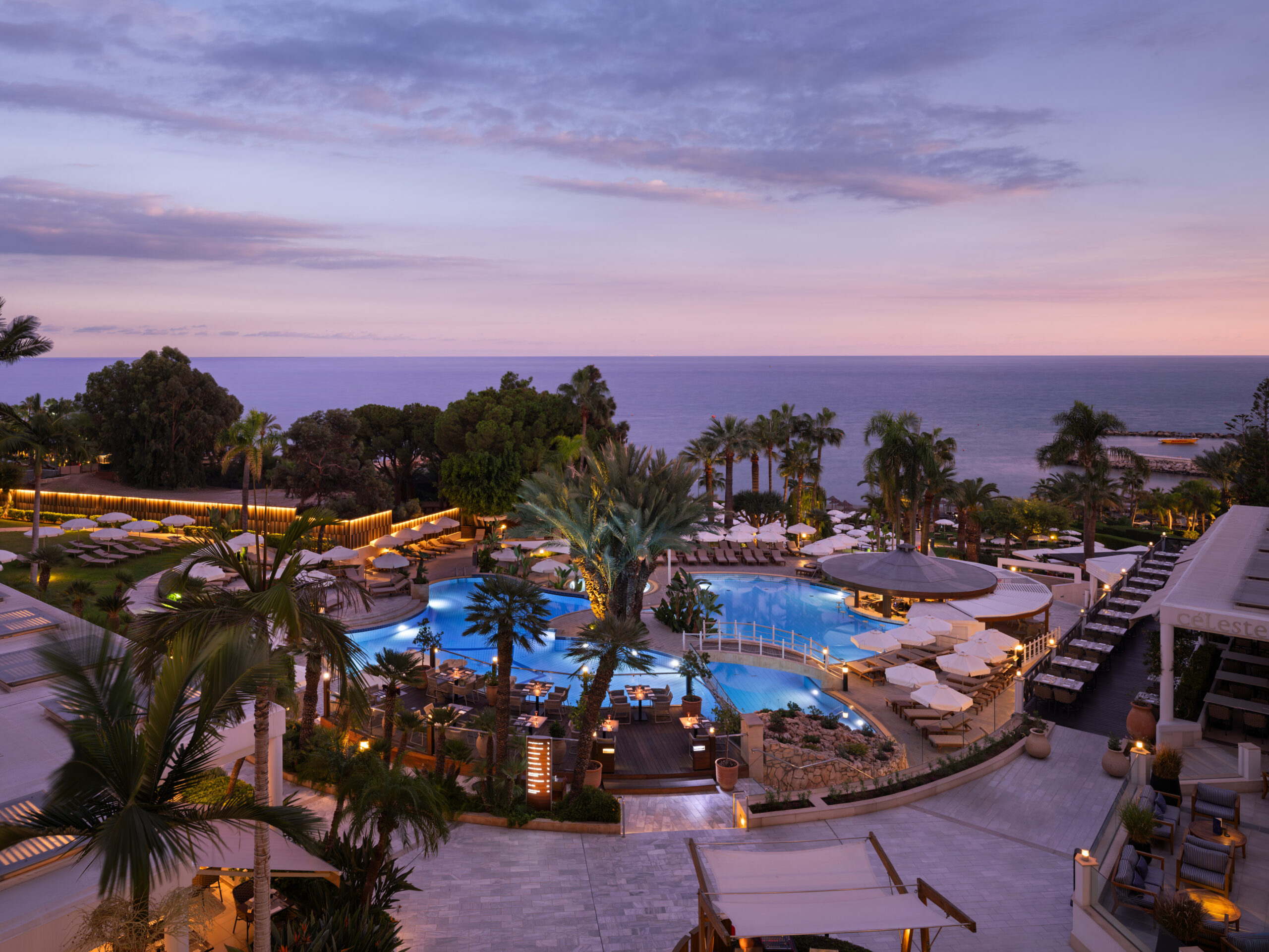 Πανοραμική θέα του Mediterranean Beach Hotel με πισίνα και Μεσόγειο στο ηλιοβασίλεμα