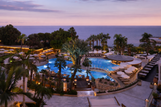 Πανοραμική θέα του Mediterranean Beach Hotel στη Λεμεσό με πισίνα και Μεσόγειο κατά το ηλιοβασίλεμα