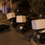 Μοτοσικλέτες διανομέων σε νυχτερινό δρόμο με αστυνομικά φώτα στο βάθος, εικονογραφική απεικόνιση