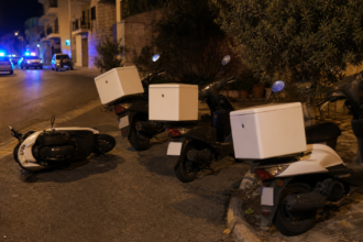 Μοτοσικλέτες διανομέων σε νυχτερινό δρόμο με αστυνομικά φώτα στο βάθος, εικονογραφική απεικόνιση
