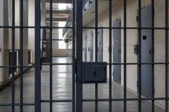 Συμβολική εικόνα κλειδωμένης πύλης και διαδρόμου σωφρονιστικού ιδρύματος