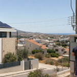 Κυπριακή γειτονιά με μία κατοικία που διαθέτει φωτοβολταϊκά και μπαταρία δίπλα σε ηλεκτρικό δίκτυο