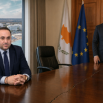 Σατιρική πολιτική σύνθεση με τον Κώστα Κουμή και τον Νίκο Χριστοδουλίδη σε απόσταση, μια άδεια υπουργική καρέκλα και μια ρωγμή στο τραπέζι