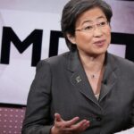 Η επικεφαλής της AMD Λίζα Σου μπροστά από το εταιρικό σήμα