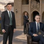 Σατιρική πολιτική εικονογράφηση με τον Χρίστο Σενέκκη καθισμένο στην υπουργική καρέκλα, τον Γιώργο Σολωμού όρθιο και μουρμουρητά έξω από τα γραφεία του ΔΗΚΟ