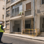 Μηχανικός επιθεωρεί φθορές σε παλαιά πολυκατοικία της Λευκωσίας με περίφραξη ασφαλείας