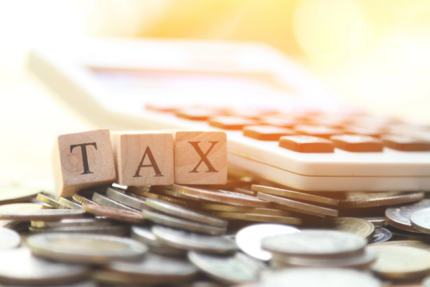 Ξύλινα γράμματα TAX πάνω σε έγγραφα και κέρματα
