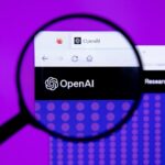 Η ιστοσελίδα της OpenAI φωτογραφημένη μέσα από μεγεθυντικό φακό
