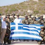 Ο Κυριάκος Μητσοτάκης με στελέχη των Ενόπλων Δυνάμεων και ελληνική σημαία κατά την επίσκεψη στο ακριτικό σύμπλεγμα