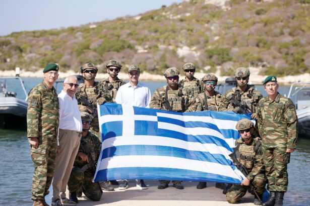 Ο Κυριάκος Μητσοτάκης με στελέχη των Ενόπλων Δυνάμεων και ελληνική σημαία κατά την επίσκεψη στο ακριτικό σύμπλεγμα