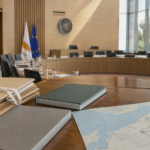 Άδεια αίθουσα κοινοβουλευτικής επιτροπής με κλειστούς αρχειακούς φακέλους και νέους φακέλους δημόσιας πολιτικής