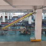 Γραμμή εμφιάλωσης με εργαζόμενους και βιομηχανικούς μεταφορικούς ιμάντες σε εργοστάσιο στη Χεγιουάν της Κίνας