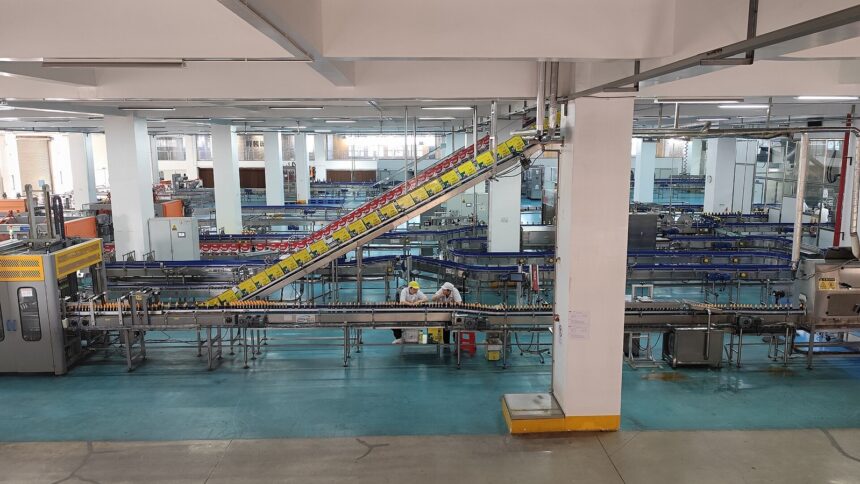 Γραμμή εμφιάλωσης με εργαζόμενους και βιομηχανικούς μεταφορικούς ιμάντες σε εργοστάσιο στη Χεγιουάν της Κίνας