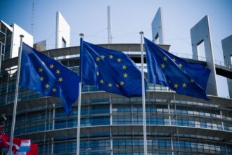 Σημαίες της Ευρωπαϊκής Ένωσης μπροστά σε κτίριο ευρωπαϊκού θεσμού