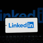 Η εφαρμογή LinkedIn σε πραγματικό κινητό τηλέφωνο μπροστά από υπολογιστή