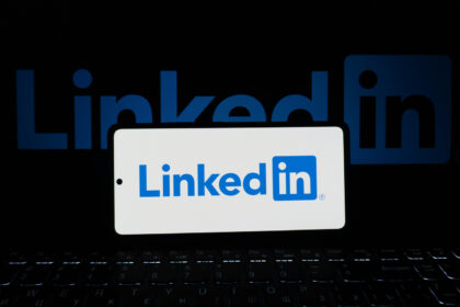 Η εφαρμογή LinkedIn σε πραγματικό κινητό τηλέφωνο μπροστά από υπολογιστή