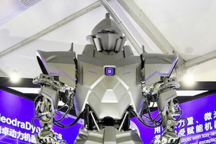 Ο Neo1 της NeodraDynamics μπροστά σε μωβ εταιρικό εκθεσιακό περίπτερο.