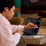 Χρήστης αγγίζει την οθόνη του νέου MacBook Pro με PROLED XDR